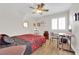 Cozy bedroom with wood-look flooring, ceiling fan, and ample natural light provides a peaceful retreat at 9339 Square Dance Pl # 103, Las Vegas, NV 89178