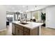 Modern kitchen featuring an island with a sink, stainless steel appliances, pendant lighting, and an adjacent dining area at 97 Tardando Ave, Henderson, NV 89015