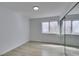 A minimalist bedroom featuring light wood floors, mirror closet, and bright natural light at 9808 Eagle Rock Ct, Las Vegas, NV 89117