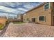 Wide backyard with stone patio, artificial turf, BBQ, and seating at 9876 Parador Cellars Ct, Las Vegas, NV 89141