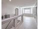 Bright hallway with wood flooring, glass railing, and a large picture window at 9876 Parador Cellars Ct, Las Vegas, NV 89141
