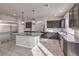 Spacious kitchen featuring dark cabinetry, stainless appliances, a large center island, and stylish pendant lighting at 9876 Parador Cellars Ct, Las Vegas, NV 89141