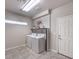 Bright laundry room featuring tile flooring, utility sink, and modern appliances at 9876 Parador Cellars Ct, Las Vegas, NV 89141