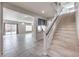 Spacious living room featuring neutral tile flooring, modern staircase, and an open floor plan at 9876 Parador Cellars Ct, Las Vegas, NV 89141