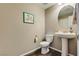 Charming half bathroom featuring a pedestal sink, round mirror, and modern fixtures at 9935 Fletcher Peak Ave, Las Vegas, NV 89178