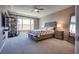 Cozy bedroom featuring a large window, neutral tones, and a comfortable bed with stylish linens at 9935 Fletcher Peak Ave, Las Vegas, NV 89178