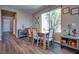 Dining area with wood floors, a large window, and a modern farmhouse-style dining table at 9935 Fletcher Peak Ave, Las Vegas, NV 89178