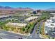 Aerial view showing commercial district with stores, landscaped roads and parking, and mountain backdrop in the distance at 10217 Queens Church Ave, Las Vegas, NV 89135