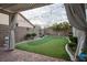 Beautiful backyard featuring a putting green, brick patio, and decorative pergola at 10217 Queens Church Ave, Las Vegas, NV 89135