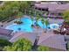 Aerial view of a community pool with palm trees, waterslides, and lounging areas, perfect for relaxation at 10217 Queens Church Ave, Las Vegas, NV 89135