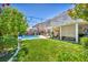 Expansive backyard with well-manicured lawn, pool, and covered patio for relaxation and entertainment at 10662 Bonchester Hill St, Las Vegas, NV 89141