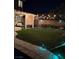 Manicured backyard with string lights, patio, and lush green lawn at 10662 Bonchester Hill St, Las Vegas, NV 89141