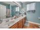 Bathroom with double sinks, a large mirror, and blue accent wall at 10662 Bonchester Hill St, Las Vegas, NV 89141