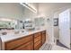 Bathroom featuring double sinks with a large vanity, a mirror, and a door leading to the toilet room at 10662 Bonchester Hill St, Las Vegas, NV 89141