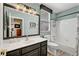 Well-lit bathroom features a dark vanity, large mirror, and a shower/tub combo with white tile surround at 10662 Bonchester Hill St, Las Vegas, NV 89141
