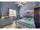 Blue bedroom featuring a ceiling fan, a window, and wall art at 10662 Bonchester Hill St, Las Vegas, NV 89141