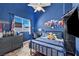 Stylish bedroom features a blue accent wall, ceiling fan, and a comfortable-looking bed with a black metal frame at 10662 Bonchester Hill St, Las Vegas, NV 89141