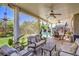 Relaxing covered patio with ceiling fans and comfortable seating that overlooks the backyard at 10662 Bonchester Hill St, Las Vegas, NV 89141