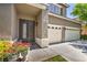Inviting front entrance with a double door, lovely potted flowers, and a well-manicured lawn at 10662 Bonchester Hill St, Las Vegas, NV 89141