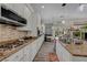 Gourmet kitchen featuring granite counters, stainless appliances, tile backsplash, and wood-look floors at 10662 Bonchester Hill St, Las Vegas, NV 89141