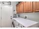 Well-equipped laundry room with front load washer and dryer and wooden cabinets above at 10662 Bonchester Hill St, Las Vegas, NV 89141