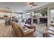 Open-concept living room and kitchen area with stone fireplace, modern appliances, and comfortable seating at 10662 Bonchester Hill St, Las Vegas, NV 89141