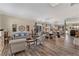 Open-concept living and dining area with wood-look flooring, neutral décor, and a mirrored wall at 10662 Bonchester Hill St, Las Vegas, NV 89141