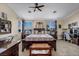 Spacious bedroom featuring a ceiling fan, two windows, and an ensuite sitting area with a vanity at 10662 Bonchester Hill St, Las Vegas, NV 89141