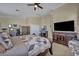 Spacious bedroom featuring tan walls, a ceiling fan, and a large dresser with an iron board at 10662 Bonchester Hill St, Las Vegas, NV 89141