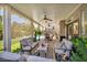 Relaxing covered patio with comfortable seating, ceiling fans, and a view of the landscaped backyard at 10662 Bonchester Hill St, Las Vegas, NV 89141