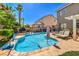 Backyard pool with stone border, mature landscaping, and lounge area at 10662 Bonchester Hill St, Las Vegas, NV 89141