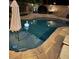 In-ground pool with lounge area, umbrella, and backyard landscaping at 10662 Bonchester Hill St, Las Vegas, NV 89141