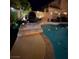 Backyard night view of pool and seating area, with outdoor lighting at 10662 Bonchester Hill St, Las Vegas, NV 89141