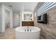 Beautiful bathroom boasts a soaking tub, stone accent wall, and modern fixtures for a spa-like experience at 10748 Steel Ridge Ct, Las Vegas, NV 89135