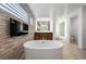 Bright bathroom boasts a soaking tub, stone accent wall, and modern fixtures for a spa-like experience at 10748 Steel Ridge Ct, Las Vegas, NV 89135