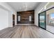 Bright bedroom with wood accent wall, stylish light fixture, and glass doors to an outdoor space at 10748 Steel Ridge Ct, Las Vegas, NV 89135