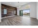 Spacious bedroom featuring a wood accent wall, sliding glass doors to a private balcony, and stylish lighting at 10748 Steel Ridge Ct, Las Vegas, NV 89135