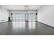 Spacious three-car garage with epoxy flooring and modern glass doors providing ample parking and storage at 10748 Steel Ridge Ct, Las Vegas, NV 89135