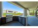 Outdoor kitchen complete with a built-in grill, stainless steel appliances, and a bar overlooks a lush backyard at 10748 Steel Ridge Ct, Las Vegas, NV 89135