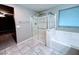 A bathroom featuring a glass-enclosed shower, soaking tub, and tile floors at 10941 Prudhoe Bay St, Las Vegas, NV 89179