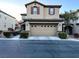 Two-story home featuring a two-car garage, stone accents, desert landscaping, and a tile roof at 10941 Prudhoe Bay St, Las Vegas, NV 89179