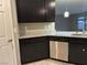 Close-up of modern kitchen featuring dark cabinetry, stainless steel appliances, and granite countertops at 10941 Prudhoe Bay St, Las Vegas, NV 89179