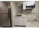 Functional kitchen with stainless steel refrigerator, white cabinets, sink, and granite countertop at 10941 Prudhoe Bay St, Las Vegas, NV 89179