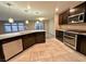 Modern kitchen with dark cabinetry, stainless steel appliances, granite countertops, pendant lighting, and tile floors at 10941 Prudhoe Bay St, Las Vegas, NV 89179