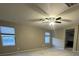 The large, open living room features a ceiling fan and natural light from the two windows at 10941 Prudhoe Bay St, Las Vegas, NV 89179