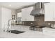 Close-up of a modern kitchen with white cabinets, stylish backsplash, and stainless steel range at 11943 Rockview Point St, Las Vegas, NV 89138