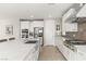 Well-lit kitchen boasts stainless steel appliances, custom white cabinetry, and expansive quartz countertops at 11943 Rockview Point St, Las Vegas, NV 89138