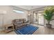 Cozy living room with a comfortable leather sofa, accent rug, and sliding glass doors to the balcony at 11943 Rockview Point St, Las Vegas, NV 89138