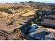 An aerial view showcases a beautiful home with a swimming pool, golf course, and mountain views at 12 Wade Hampton Trl, Henderson, NV 89052