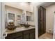 Bathroom featuring dual vessel sinks, a large mirror, and decorative mosaic tile accents at 12 Wade Hampton Trl, Henderson, NV 89052